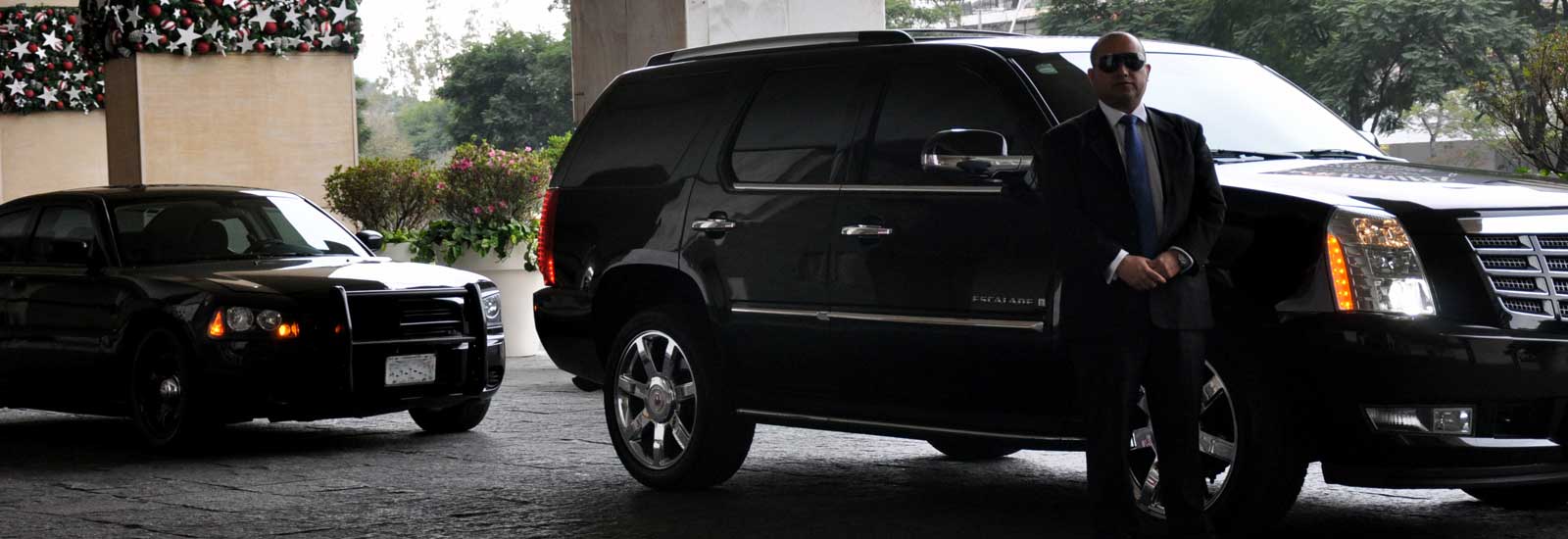 Professional security detail with luxury SUV fleet and bodyguard